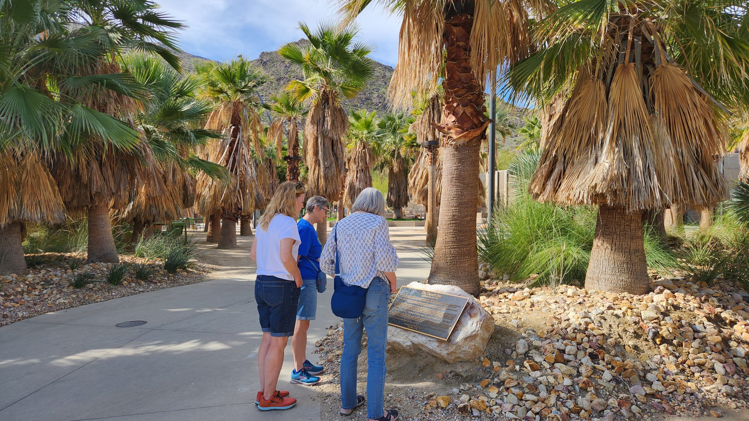 Visitors to the Downtown Park read the bronze plaque, donated by PSPF, which provides a brief history of the Desert Inn.  (PSPF, February 2024)